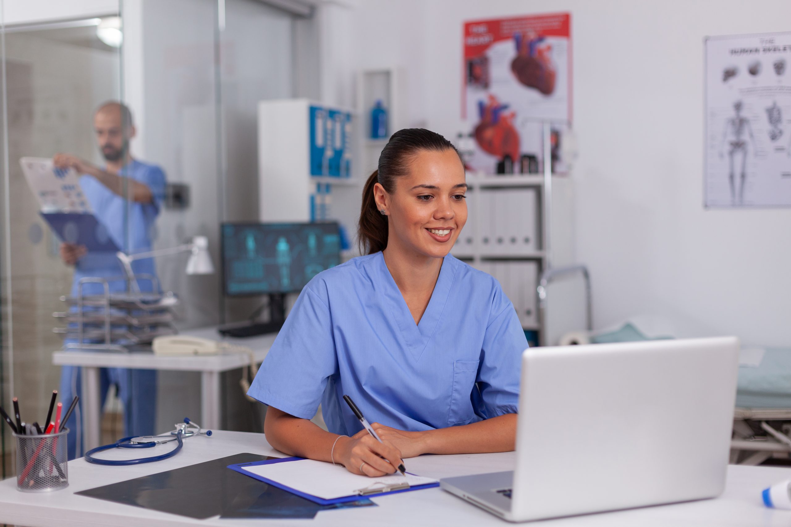 smiling nurse using laptop computer 2025 02 19 11 44 35 utc 1 scaled